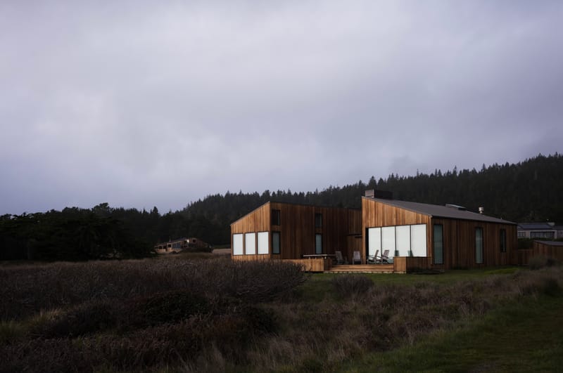 A wooden house at dusk under a violet sky